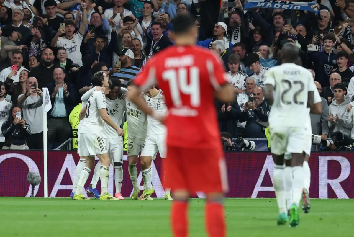 Real Madrid players celebrate their second goal scored by Real Madrid's Brazilian forward #07 Vinicius Junior during the UEFA Champions League knockout round play-off second leg football match between Real Madrid CF and SL Benfica at Santiago Bernabeu Stadium in Madrid on February 25, 2026. (Photo by Thomas COEX / AFP)