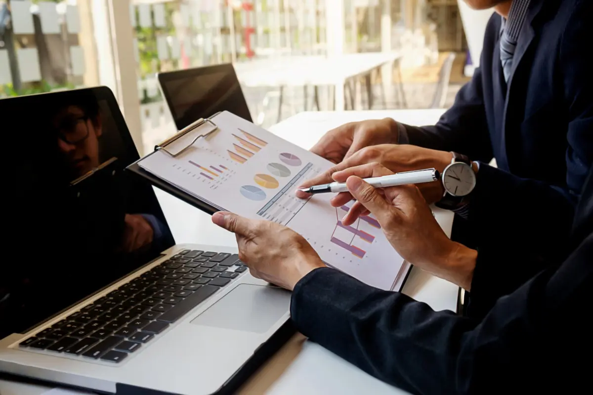 Business concept. Business people discussing the charts and graphs showing the results of their successful teamwork. Selective focus.