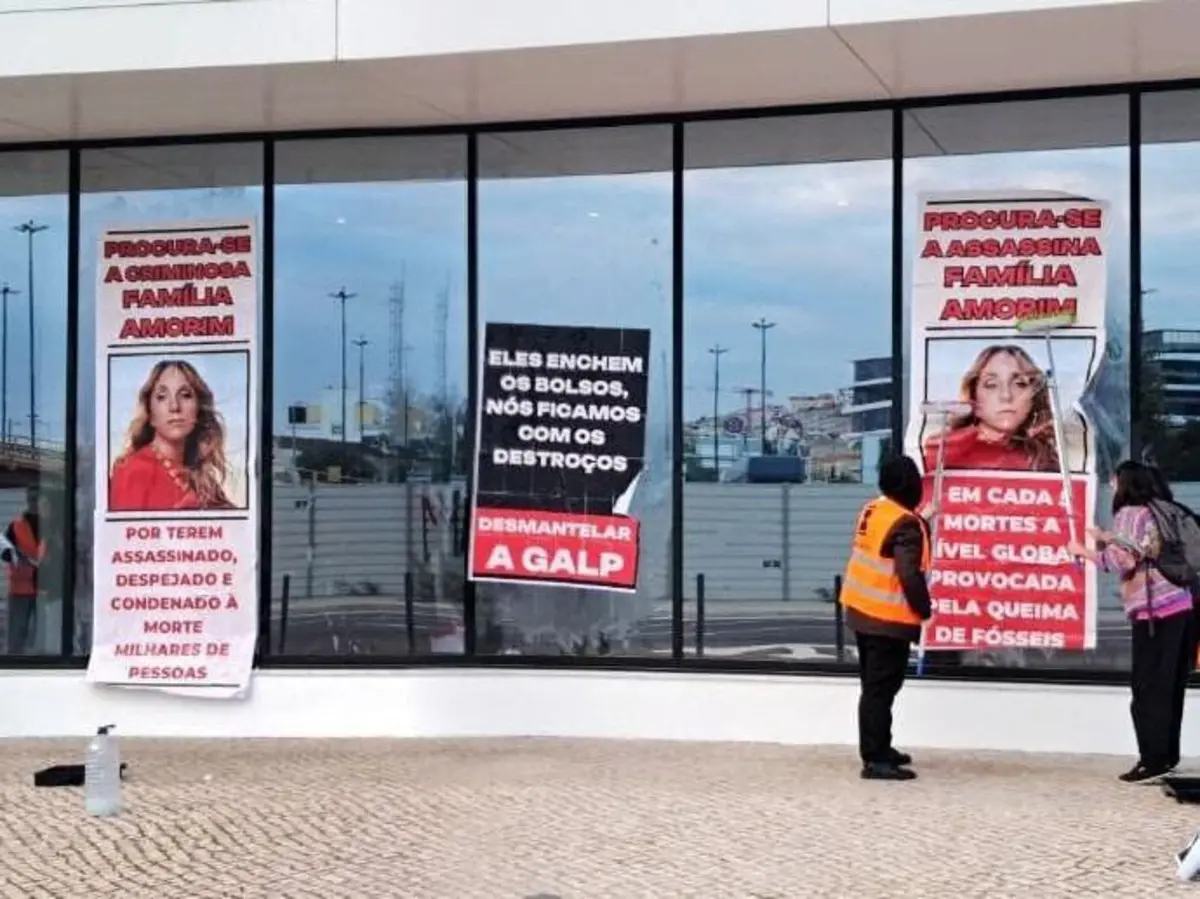 Imagem de contexto do artigo "Procura-se a criminosa família Amorim." Ativistas do Climáximo colam cartazes de protesto na sede da Galp