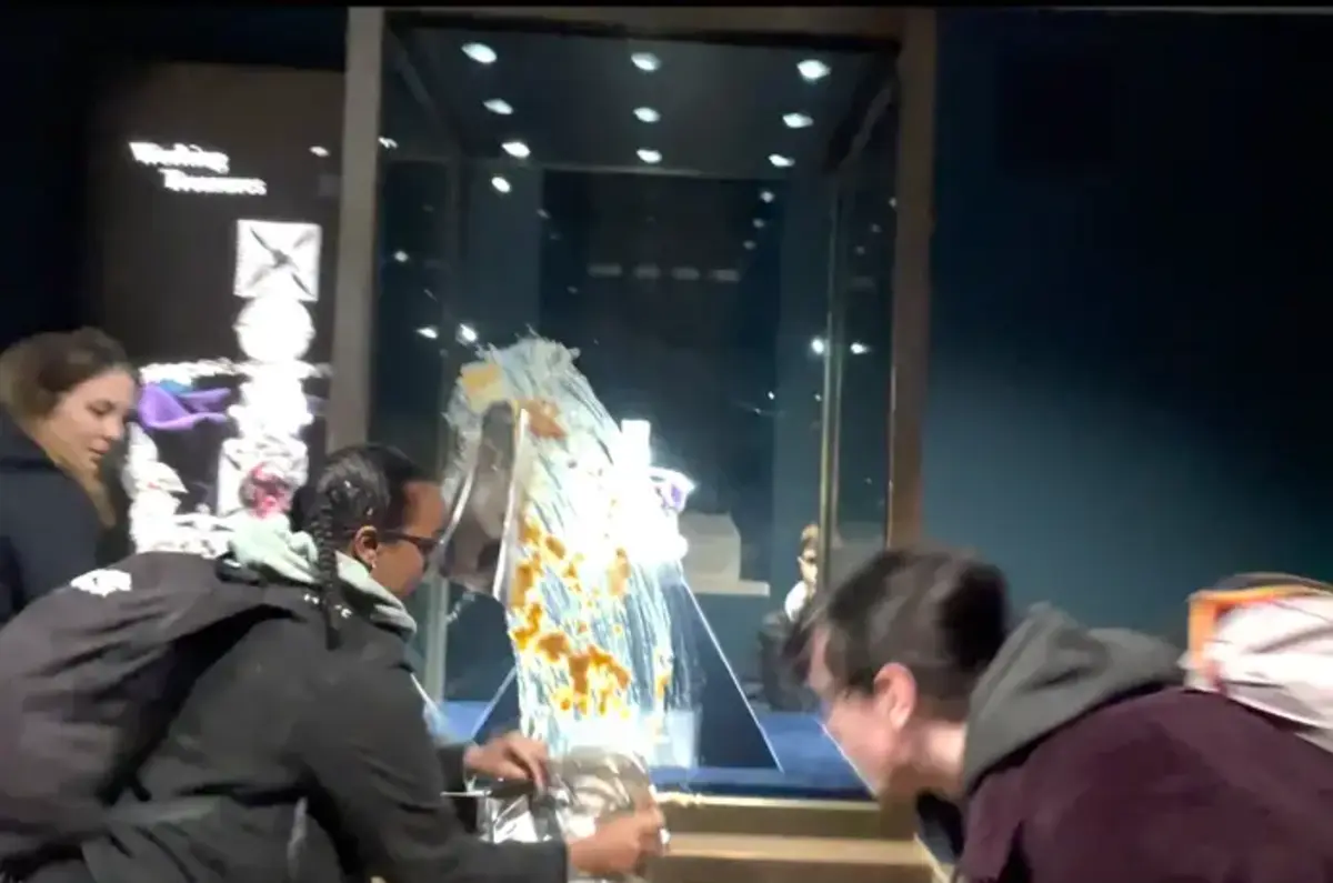 Print de vídeo que mostra ativistas a atirar comida contra vitrine na Torre de Londres