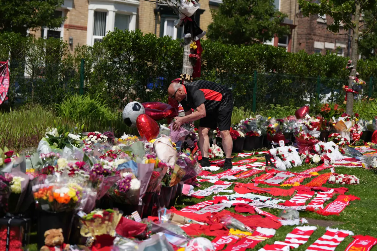 Imagem de contexto do artigo "You'll never walk alone, lad from Portugal": bandeira a meia haste, camisolas e flores em Anfield na homenagem a Jota. Veja as imagens