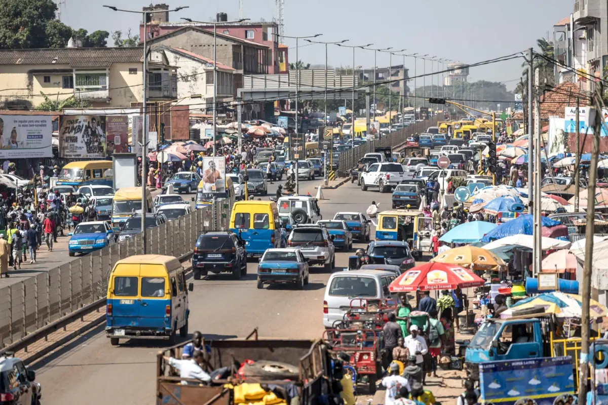 A general view of vehicles driving past a market in Bissau, on November 28, 2025. Life limped back to normal on Friday in the capital of volatile Guinea-Bissau after the west African nation's fifth coup that came on the heels of presidential and parliamentary polls.