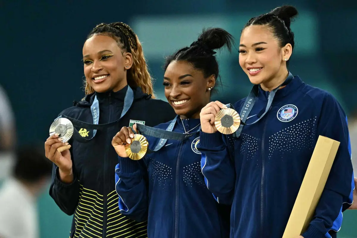A norte-americana Simone Biles com a brasileira Rebeca Andrade e a também norte-americana Sunisa Lee