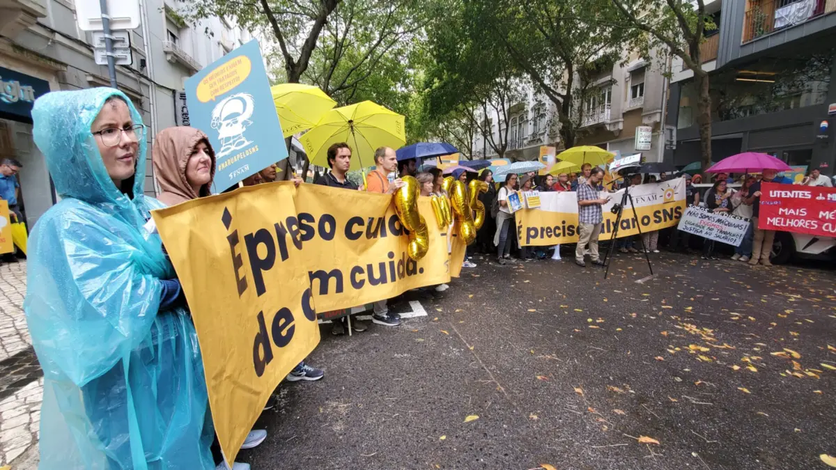 Sobressaem balões dourados que assinalam os 45 anos do SNS e vários cartazes com mensagens como "Os médicos exigem ser tratados com respeito"