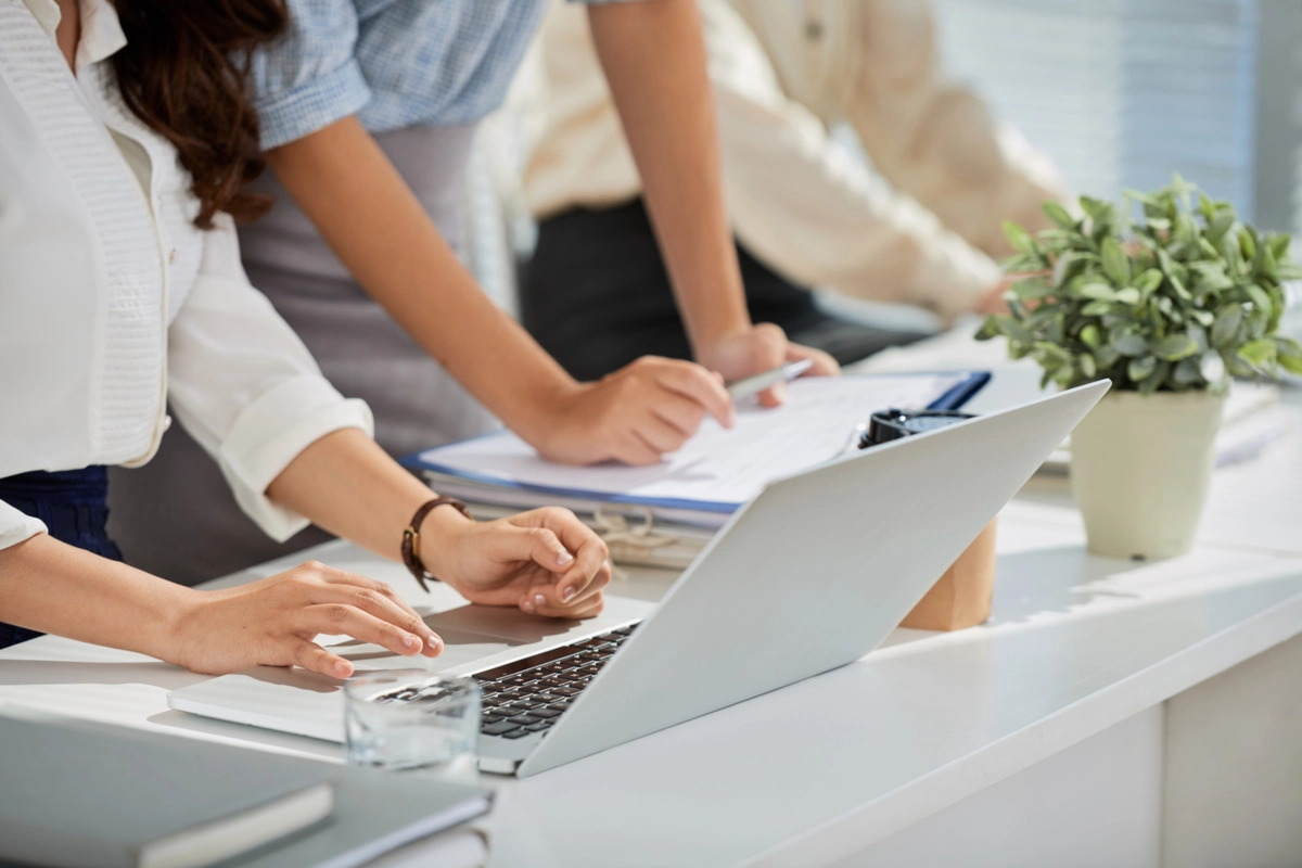 Cropped image of business ladies reading e-mails on laptop screen