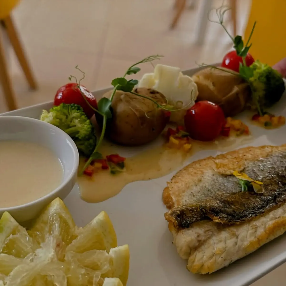 Faz-se um filete de robalo com pimentos salteados, batata a murro e molho beurre blanc que é particularmente elegante e leve